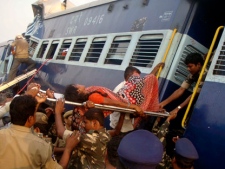 Rescuers evacuate an injured woman from the site of a train accident at a station near Penukonda, about 170 kilometres north of Bangalore, India, Tuesday, May 22, 2012. The passenger train rammed into a parked freight train and burst into flames before dawn Tuesday, killing more than 20 people, officials said. (AP Photo)