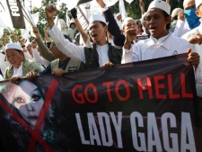 Muslim men shout slogans during a rally against U.S. pop singer Lady Gaga outside the U.S. Embassy in Jakarta, Indonesia, Friday, May 25, 2012. Protesters demonstrated against Lady Gaga's concert that is scheduled to be held on June 3, 2012. (AP Photo/Dita Alangkara)