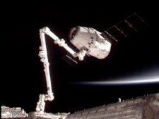This image provided by NASA-TV shows the SpaceX Dragon commercial cargo craft, top, after it was grappled by the Canadarm2 robotic arm and connected to the International Space Station on Friday, May 25, 2012. Dragon is scheduled to spend about a week docked with the station before returning to Earth for retrieval. (AP Photo/NASA)