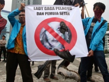 Muslim protesters throw shoes at a defaced poster of US pop singer Lady Gaga during a protest against her concert that is scheduled to be held on June 3, in Jakarta, Indonesia, Thursday, May 24, 2012. Lady Gaga might have to cancel her sold-out show in Indonesia because police worry her sexy clothes and dance moves undermine Islamic values and will corrupt the country's youth. The writing on the poster reads "Lady Gaga is a prostitute and Satan worshipper." (AP Photo/Tatan Syuflana)