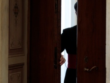 A prelate opens the door of Pope Benedict XVI's private library prior to the start of Pontiff's meeting with Costa Rican President Laura Chinchilla at the Vatican, Monday, May 28, 2012. (AP Photo/Gregorio Borgia, Pool)