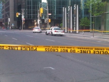 Police vehicles and caution tape are seen in this photograph after glass fell from a building on Wellington Street West on Monday, May 28, 2012. 