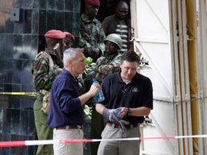 Kenya paramilitary soldiers secure the area as American investigators work at the site of an explosion to assist Kenyan officials in Nairobi, Kenya on Tuesday, May 29, 2012. An explosion ripped through a building full of small shops in Nairobi a day earlier, injuring at least 33 people, including a woman who blamed the blast on a "bearded man" who left behind a bag shortly before the detonation. (AP Photo/Khalil Senosi)