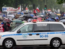 Protesters wait patiently in a slow rain and under the watchful eye of police to march through the streets of Montreal in support of the student strike and to protest against bill 78 on Saturday, June 2, 2012. THE CANADIAN PRESS/Peter McCabe
