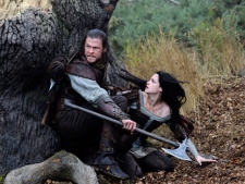 This film image released by Universal Pictures shows Chris Hemsworth, left, and Kristen Stewart in a scene from "Snow White and the Huntsman". (AP Photo/Universal Pictures, Alex Bailey)