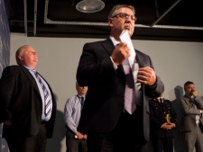 Toronto Mayor Rob Ford, left, stands by as Det. Sgt. Brian Borg, centre, makes his way to the podium at a news conference at Toronto Police Headquarters on Sunday, June 3, 2012. Police continue to investigate the Saturday's shooting at the city's Eaton Centre mall which resulted in one death and seven injuries. THE CANADIAN PRESS/Chris Young