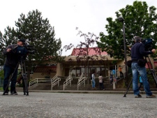 Television cameramen film False Creek Elementary School after a human hand was delivered to the school in Vancouver, B.C., on Tuesday, June 5, 2012. A human foot was also delivered to another Vancouver school Tuesday. (THE CANADIAN PRESS/Darryl Dyck)
