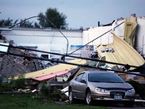 A car sits in front of a damaged building in Midland Ontario, Wednesday June 23, 2010 after a severe storm harbouring a suspected tornado tore through the town. (Benjamin Ricetto/THE CANADIAN PRESS)