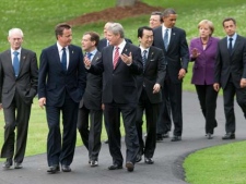 Canadian Prime Minister Stephen Harper speaks with United Kingdom Prime Minister David Cameron as they walk with other G8 leaders to the family photo at the G8 Summit in Huntsville, Ont., on Friday June 25, 2010. (Adrian Wyld/THE CANADIAN PRESS)