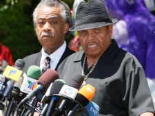 In this June 29, 2009 file photo, the Rev. Al Sharpton, left, listens as Joe Jackson, Michael Jackson's father, speaks at a news conference in front of the the Jackson family residence in Encino, Calif. (AP Photo/Charles Dharapak, file)