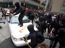 Activists attack a police car in Toronto's financial district during the G20 Summit Saturday, June 26, 2010. (THE CANADIAN PRESS/Darren Calabrese)