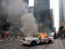 A police car burns after G20 summit protesters set fire to it in downtown Toronto on Saturday, June 26, 2010. (THE CANADIAN PRESS/Chris Young)