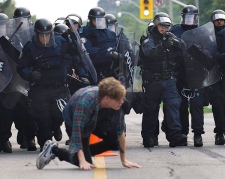 A protester crawls as he is chased by police officers during G20 demos in Toronto on Saturday, June 26, 2010. (THE CANADIAN PRESS/Adrien Veczan)