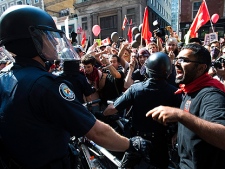Activists and protesters argue and fight with police as they march along the streets of downtown Toronto during the G8/G20 Summits on Friday, June 25, 2010. (AP Photo/The Canadian Press, Ryan Remiorz)