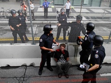 A demonstrator is arrested by Canadian police officers near the fence that surrounds the G20 Summit venue in Toronto, Canada, Saturday June 26, 2010. (AP Photo/Lefteris Pitarakis)