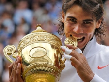 Rafael Nadal bites the trophy, after defeating Tomas Berdych in the men's singles final on the Centre Court at the All England Lawn Tennis Championships at Wimbledon, Sunday, July 4, 2010. (AP Photo/Anja Niedringhaus)