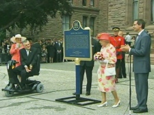 Queen Elizabeth II stands near a plaque unveiled during her farewell ceremony at Queen's Park in Toronto on July 6, 2010. 