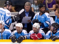 Prime Minister Stephen Harper, centre, holds a clipboard while coaching behind the bench at Hockey Night in Barrie, a fundraiser to raise money for the Royal Victoria Hospital's cancer care centre, in Barrie, Ont., Thursday, August 12, 2010. (THE CANADIAN PRESS/Darren Calabrese)