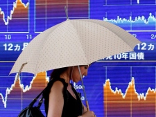 A woman walks past an electronic stock indicator in Tokyo, Tuesday, Aug. 17, 2010. Sustained strength in the yen magnified lackluster sentiment in Japan, where the Nikkei 225 stock average fell 34.99 points, or 0.4 percent, to 9,161.68. (AP Photo/Shizuo Kambayashi)