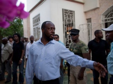 Haiti's presidential candidate and hip hop artist Wyclef Jean , center, is seen surrounded by security at his mother's house in Croix de Bouquets, Haiti, Wednesday, Aug. 18, 2010. 