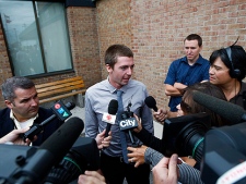 National Post staff photographer Brett Gundlock (centre) is interviewed by media outside court in Toronto, Monday, Aug.23, 2010 after charges against him and freelance photographer Colin O'Connor (back right) were dropped. G20-related charges are being dropped against some while others are being told to come back later as a crush of people make court appearances Monday.With 303 people scheduled to appear, police say it's one of the largest mass court appearances Toronto has ever seen. (THE CANADIAN PRESS/Nathan Denette)