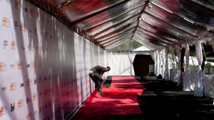 A worker lays the red carpet at Roy Thompson Hall as final preparations are made for the Toronto International Film Festival in Toronto on Wednesday, Sept. 5, 2012. (The Canadian Press/Chris Young)