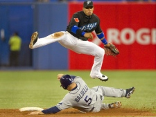 Toronto Blue Jays' Yunel Escobar leaps over Tampa Bay Rays' Rocco Baldelli while turning a double play in the second inning of MLB baseball action in Toronto Friday, September 10, 2010. (THE CANADIAN PRESS/Darren Calabrese)