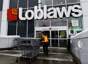 A Loblaws employee brings in shopping carts in Toronto on Wednesday, Feb. 18, 2009. (THE CANADIAN PRESS/Nathan Denette)