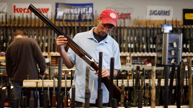 Man looks at a rifle at a gun store