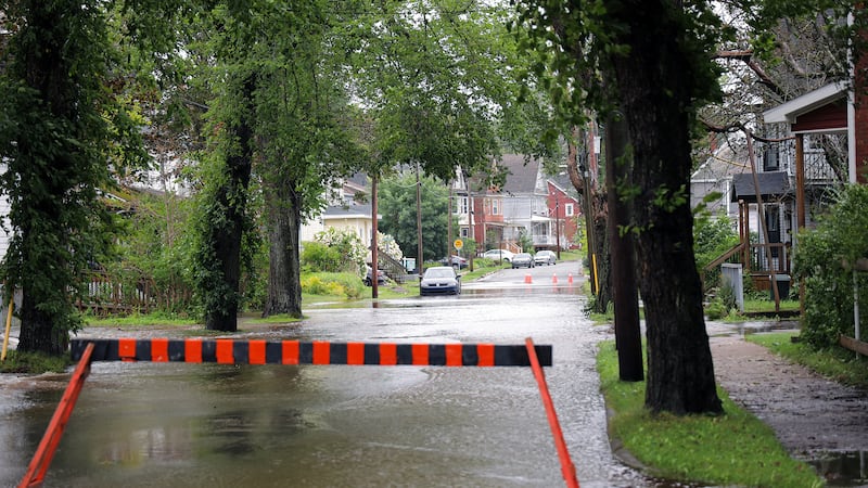 A barricade is put up in front of a flooded street.