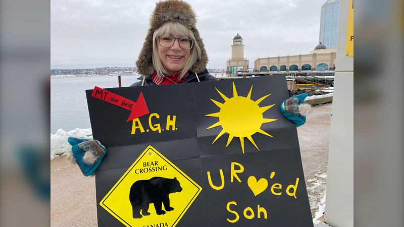April Harris is pictured at the Halifax dockyard holding a sign for her son who deployed aboard the HMCS Charlottetown on Feb. 1, 2025. (Vanessa Wright / CTV Atlantic)