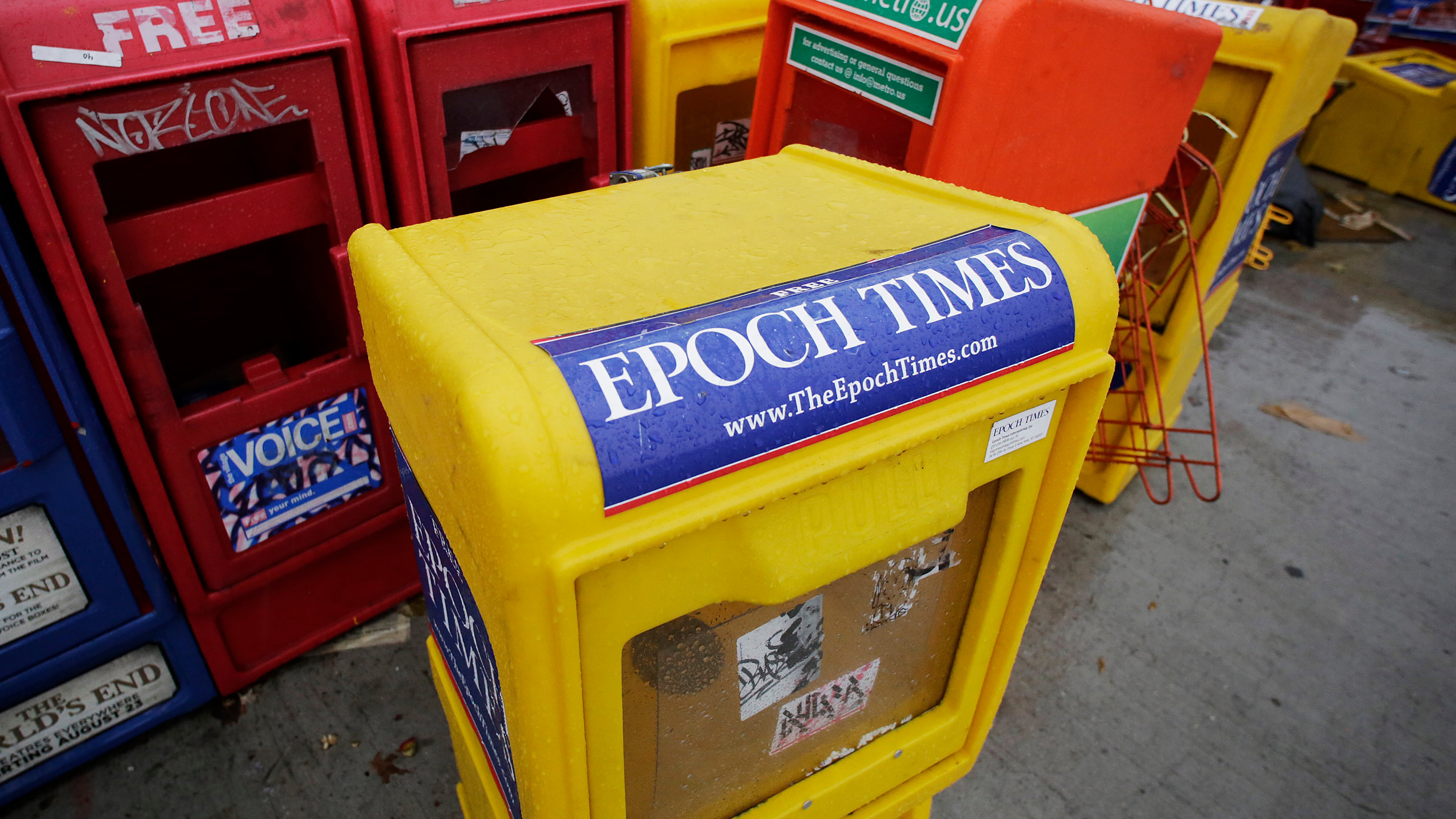 Plastic newspaper racks for The Epoch Times, The Village Voice and other newspapers are shown in New York on Nov. 27, 2013. (Mark Lennihan / AP Photo)