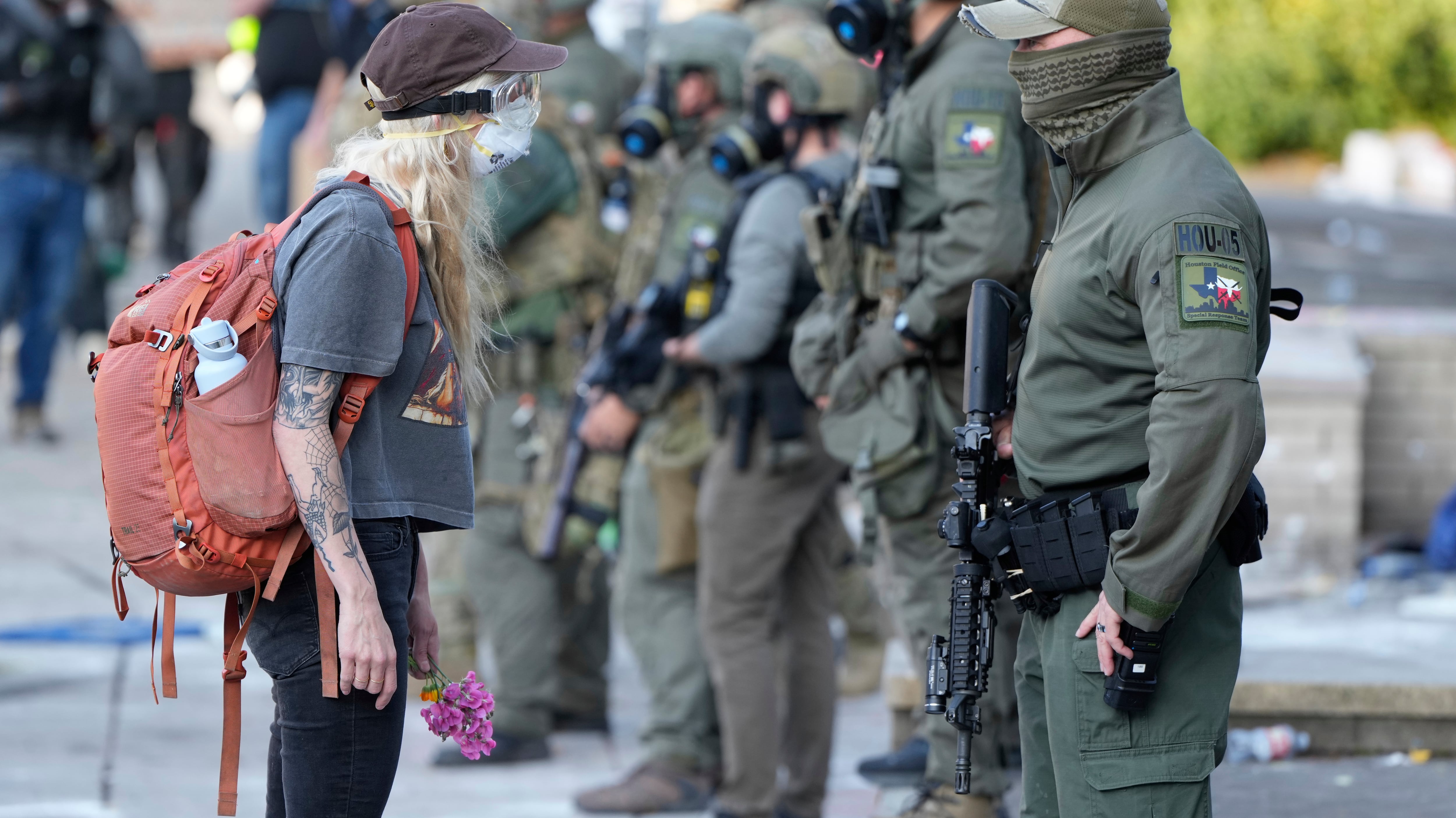 A woman stands off with a law enforcement officer outside the U.S. Immigration and Customs Enforcement building during a protest in Portland, Ore., on June 14, 2025. (Jenny Kane / AP Photo)