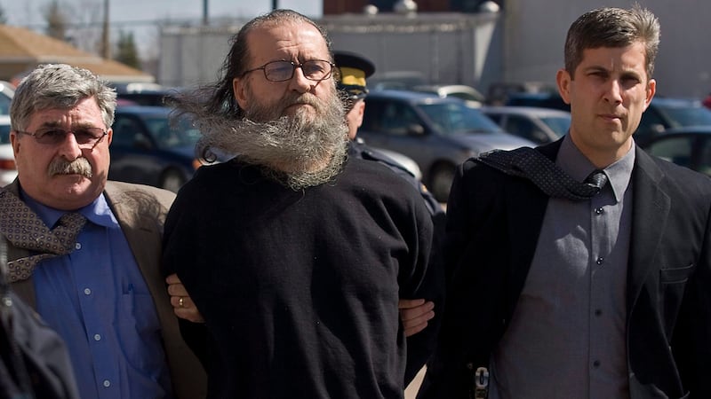 RCMP officers escort 62-year-old Romeo Jacques Cormier to court  in Moncton, N.B. on Thursday, March 25, 2010. (THE CANADIAN PRESS/Andrew Vaughan)