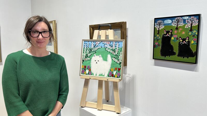 Sarah Jones, curator and co-owner of Jones Auction House in Saint John, N.B., is pictured with artwork by Maud and Everett Lewis. (Avery MacRae/CTV Atlantic)