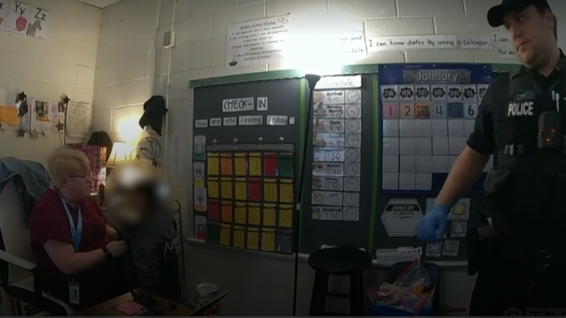 A six-year-old Virginia boy, whom a reading specialist is holding, is shown in a screengrab after he shot his elementary school teacher in January 2023.