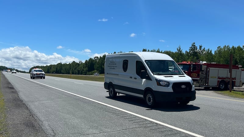 A coroner's van travels down a highway in New Brunswick on July 10, 2026, as part of a procession honouring two P.E.I. paramedics killed in an ambulance crash on July 7, 2026. (Avery MacRae/CTV News Atlantic)