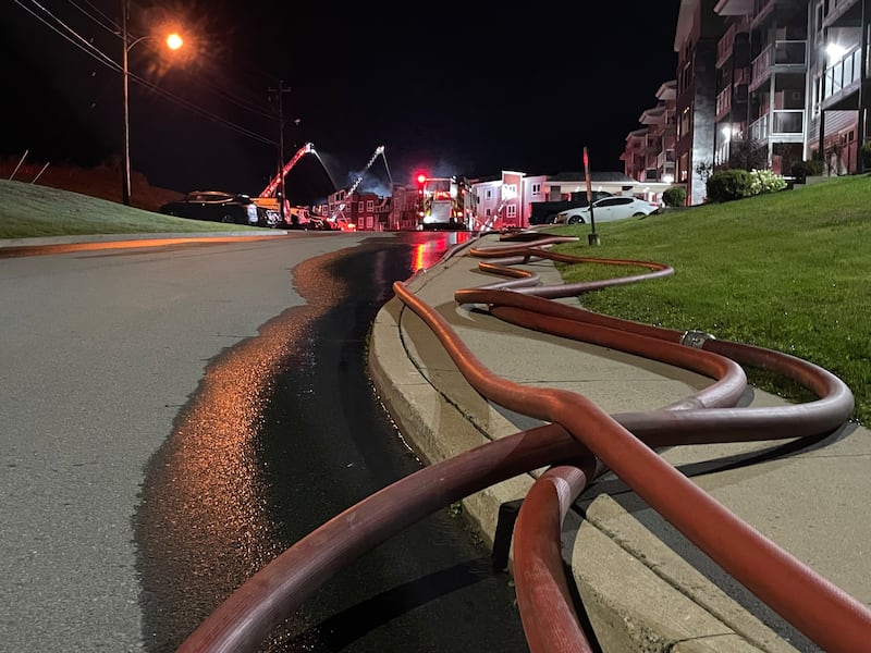 Water hoses are pictured near the scene of an apartment fire in Middle Sackville, N.S. (Carl Pomeroy/CTV Atlantic)