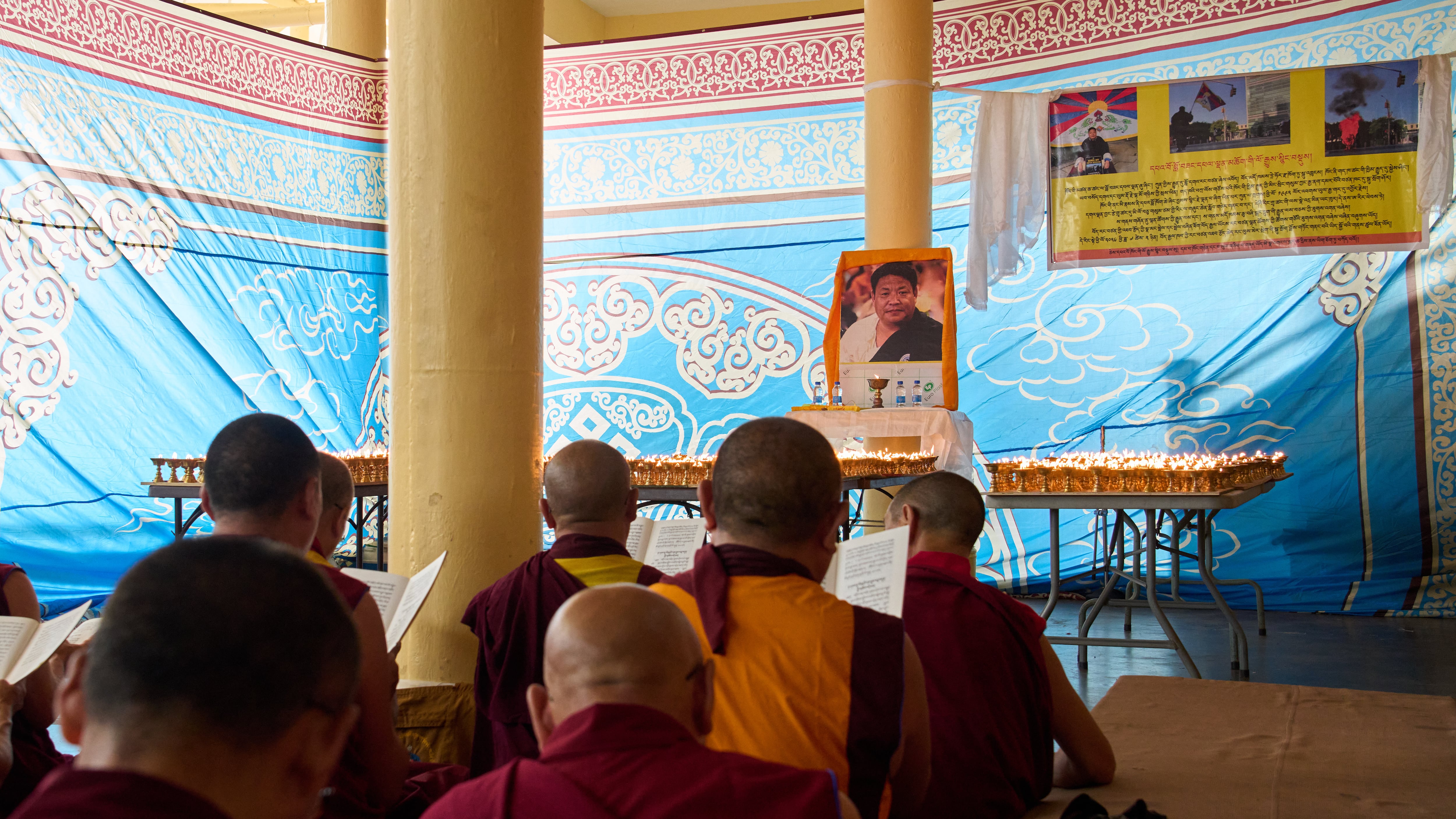 Exiled Tibetans hold a special prayer ceremony at the Tsuglakhang temple in Dharamshala, India on July 4, 2026 for Lobsang Palden, the man who died after setting himself on fire. Palden's photograph is displayed in front of them. (Ashwini Bhatia / AP Photo)