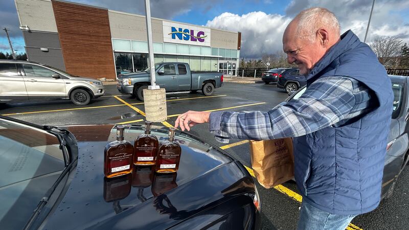 Jerry Wambolt shows his three bottles of newly-purchased bourbon outside an NSLC location in Cole Harbour, N.S. (Jonathan MacInnis/CTV Atlantic)