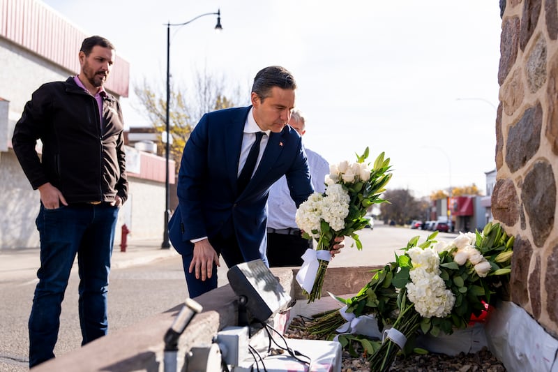 Conservative Leader Pierre Poilievre lays flowers for the victims of a fire that killed four soldiers at CFB Wainwright, at the Memorial Clock Tower on Main Street, in Wainwright, Alta., on Monday, Oct. 19, 2026. THE CANADIAN PRESS/Christopher Katsarov