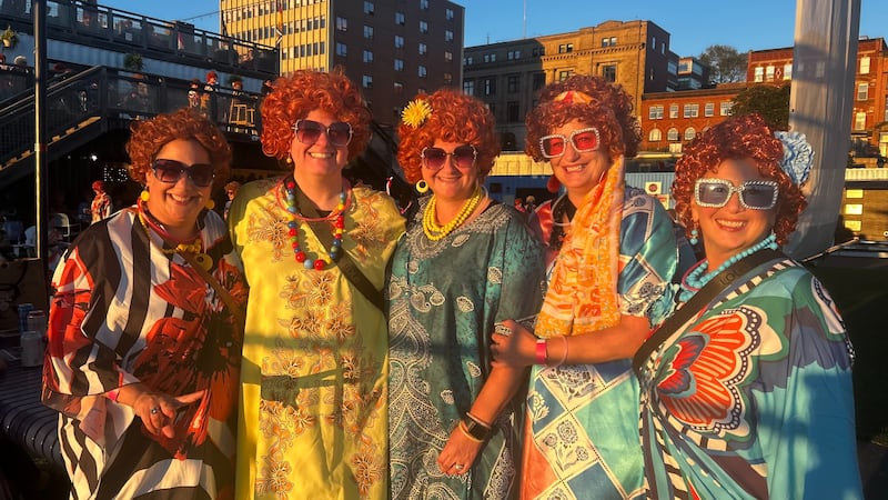 Five women dressed up as Mrs. Roper pose for a photo.