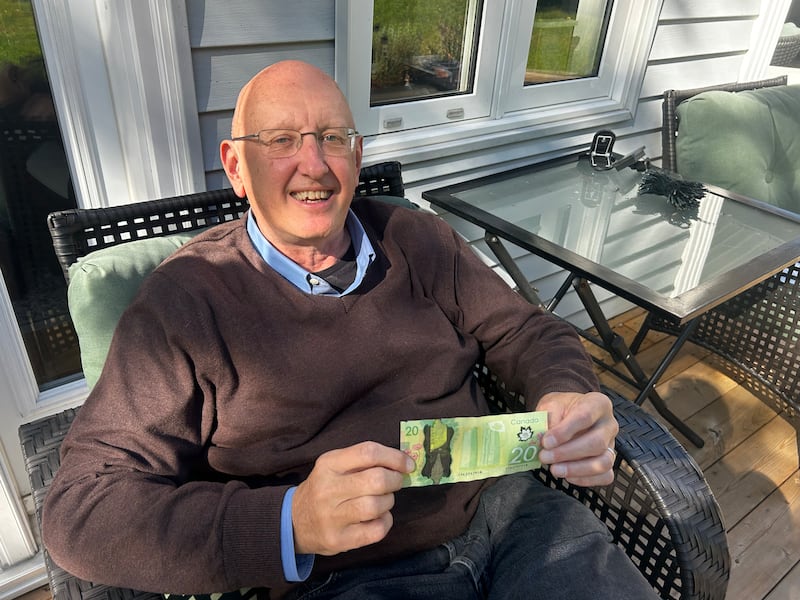 David Johnson at his home in Sydney River, N.S., holding a $20 with Queen Elizabeth II on it. (Ryan MacDonald/CTV News Atlantic)
