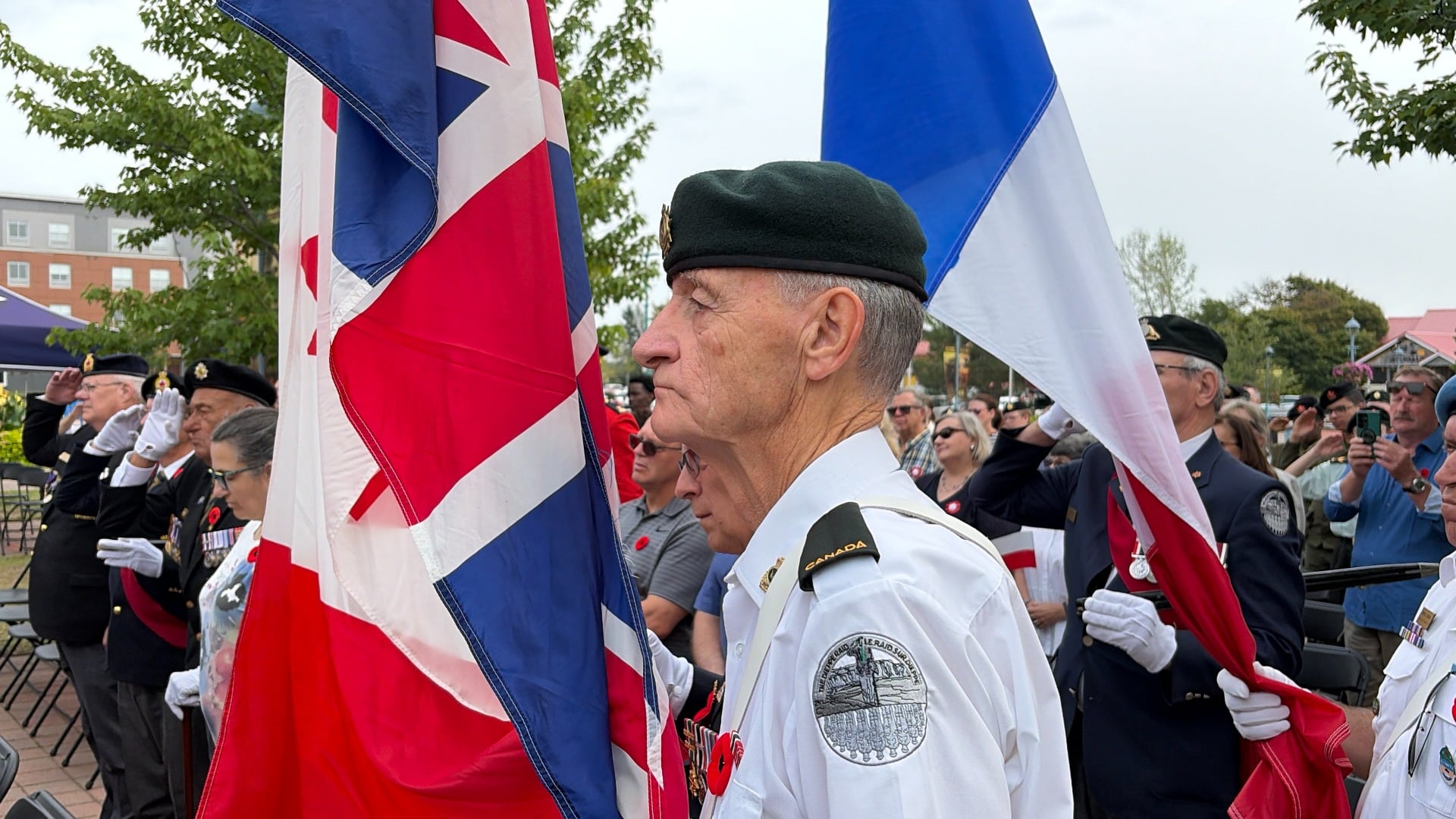 A military member is pictured holding a flag.