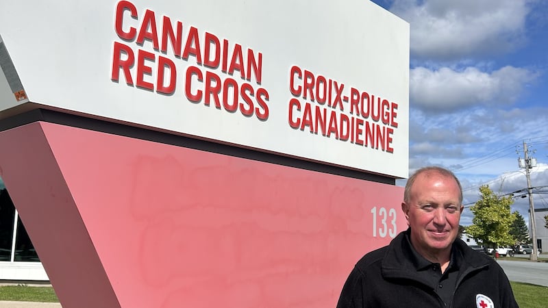Ancel Langille in front of Red Cross sign