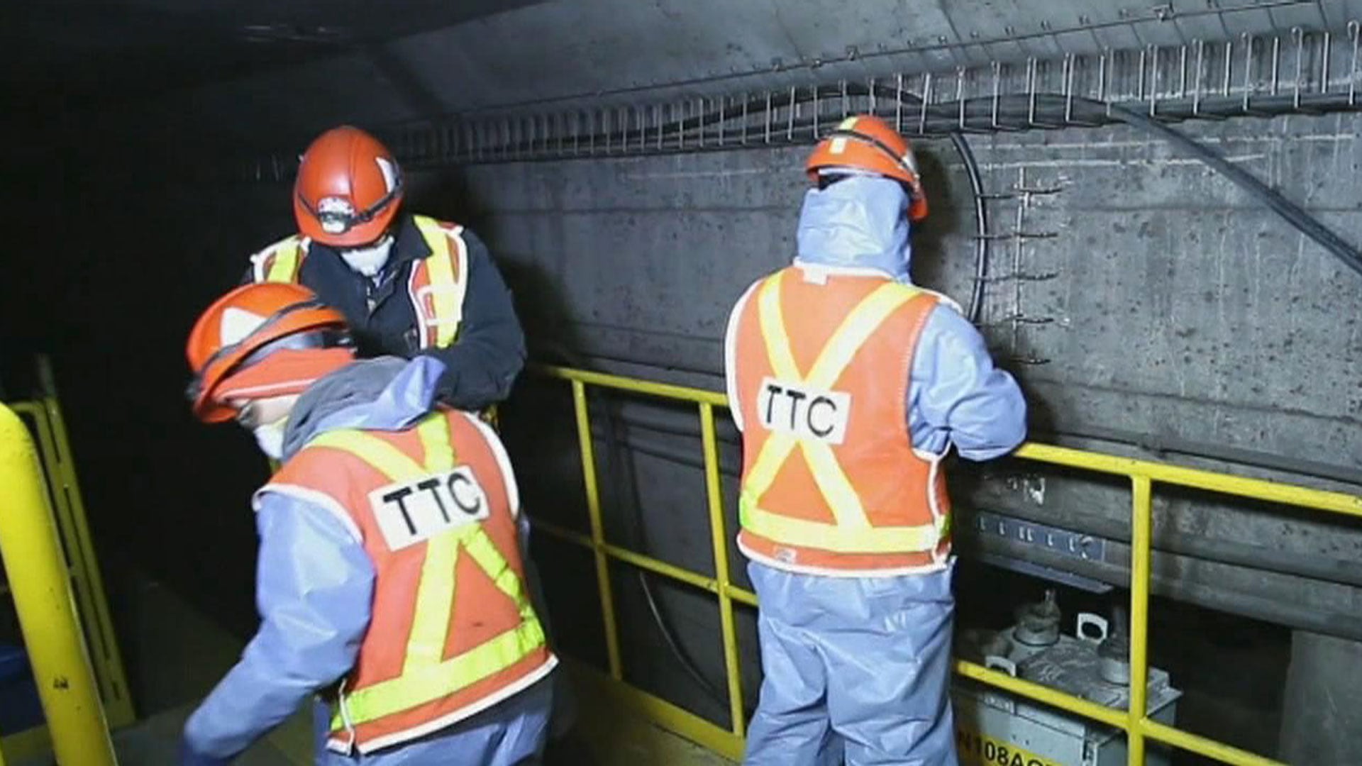 TTC workers work inside a subway tunnel.