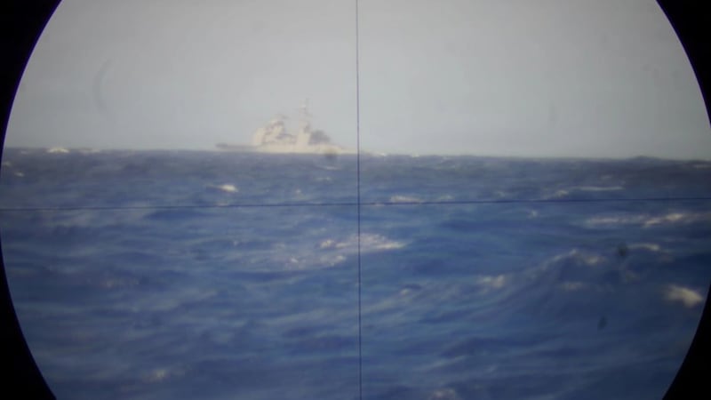 The decommissioned guided-missile cruiser USS Mobile Bay, viewed through the periscope of Royal Canadian Navy Victoria-class long-range patrol submarine HMCS Corner Brook on July 12, 2026. (Royal Canadian Navy)