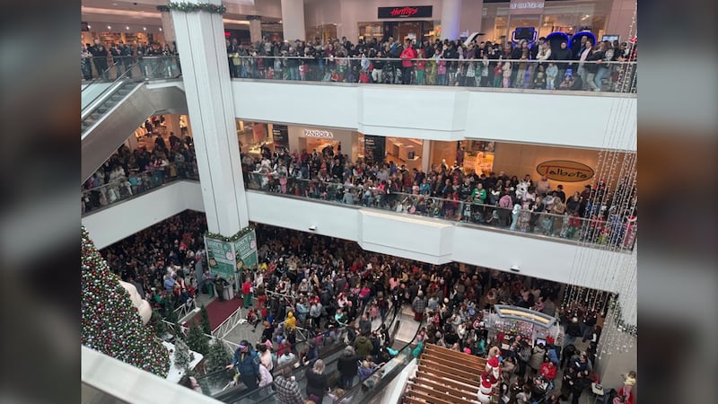 Hundreds of people are pictured on three floors of a mall.