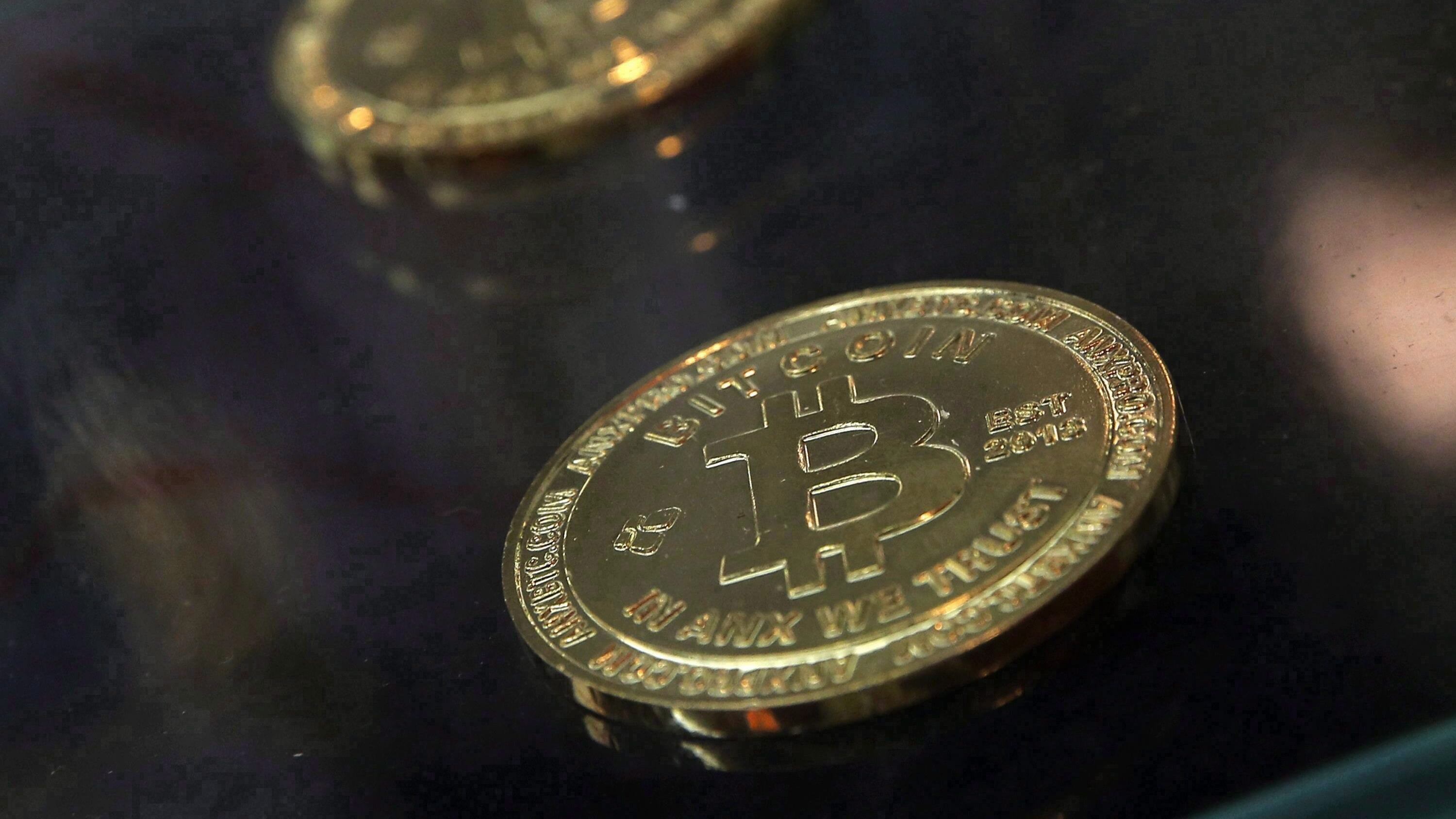 Physical bitcoins are displayed next to a Bitcoin ATM in Hong Kong, Friday, Dec. 8, 2017. THE CANADIAN PRESS/AP-Kin Cheung