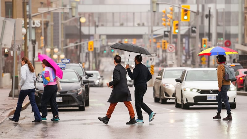 People walk as a heavy fog hangs over downtown Ottawa on  April 16, 2026. (Sean Kilpatrick / The Canadian Press)